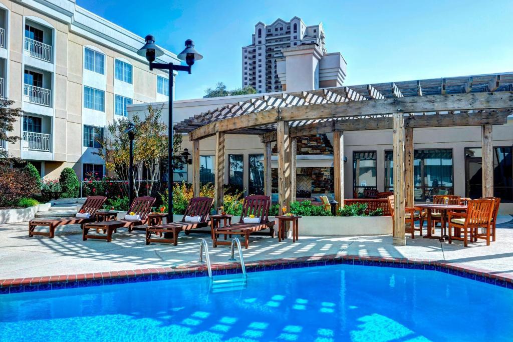 a pool at a hotel with chairs and a pergola at Sheraton Atlanta Perimeter North in Atlanta