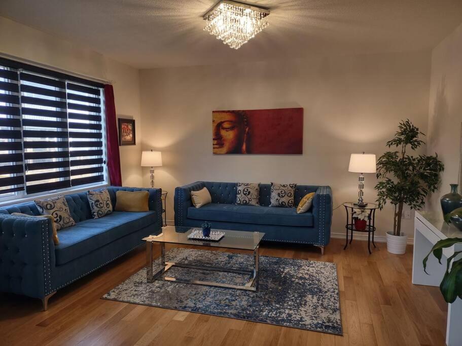 a living room with two blue couches and a coffee table at A home away from home in Niagara Falls