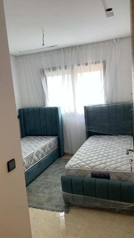 - une chambre avec deux lits et un canapé dans l'établissement Adorable Appartement meublé en plein centre ville, à Kenitra