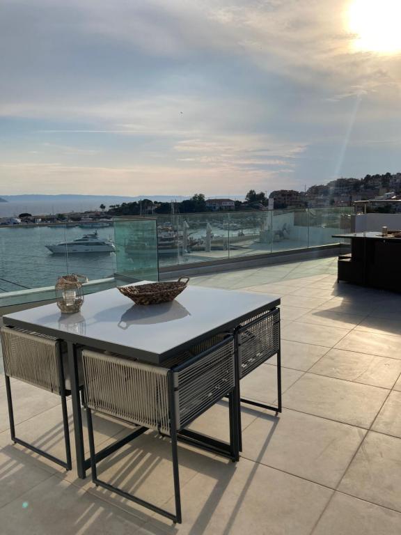 a table on a roof with a view of the water at Wide Blue Luxury Boutique Suites in Neos Marmaras