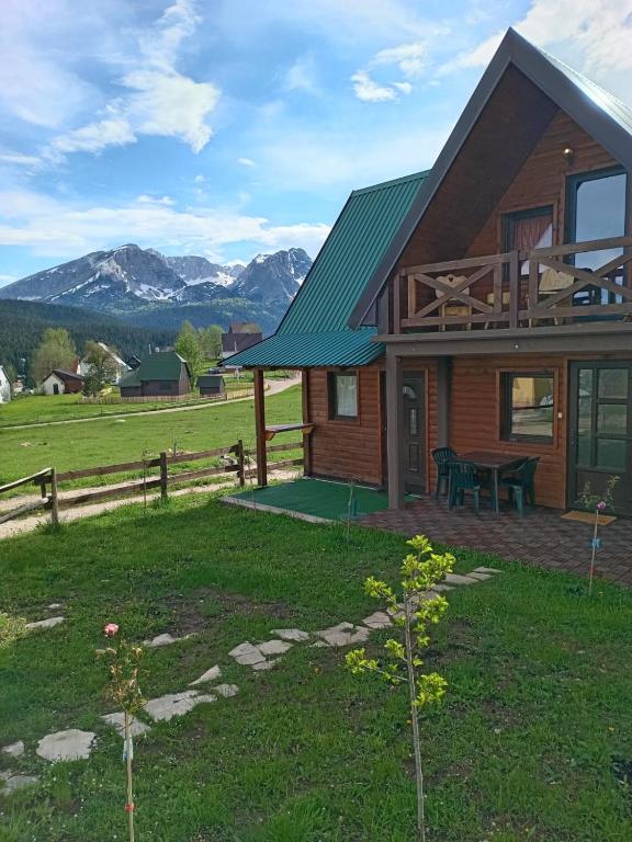 una casa con tetto verde e tavolo da picnic di Chalet Hill Zabljak a Žabljak