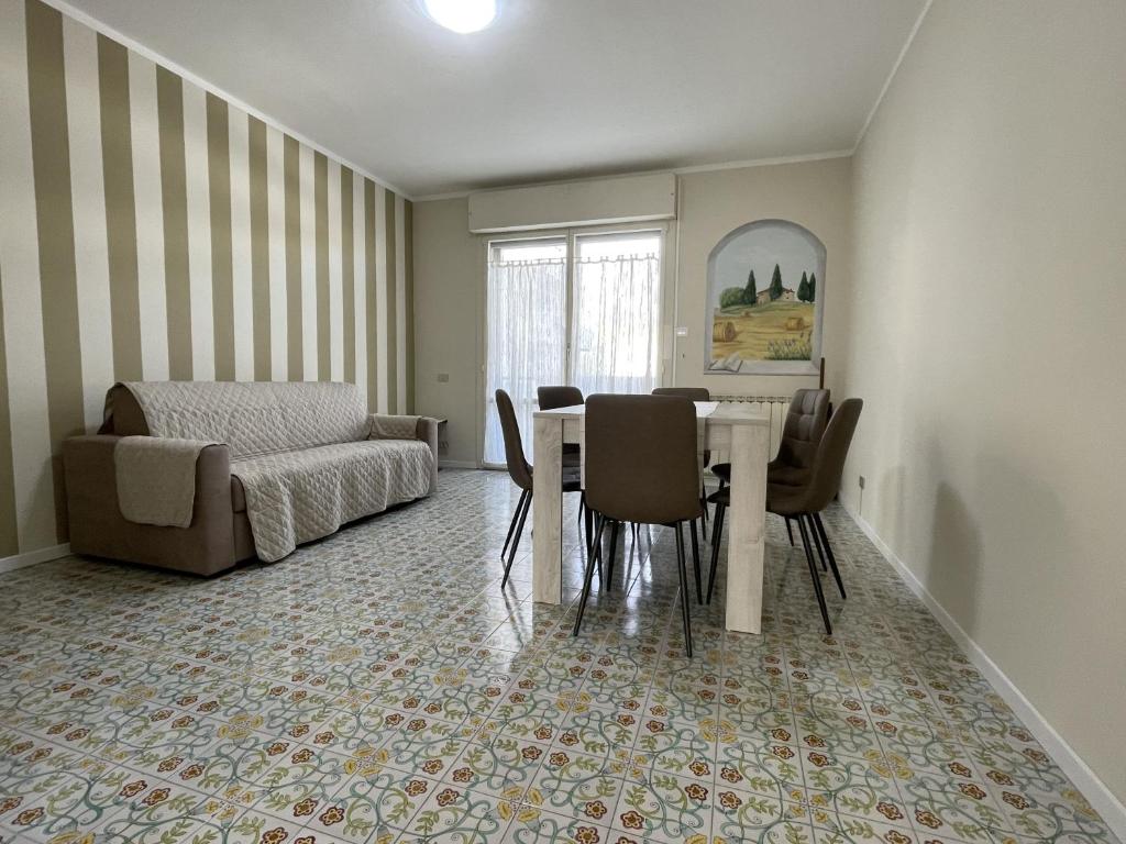 een woonkamer met een tafel en stoelen en een bank bij Stefano's Guests House: 2 bedrooms & parking in Viareggio in Viareggio