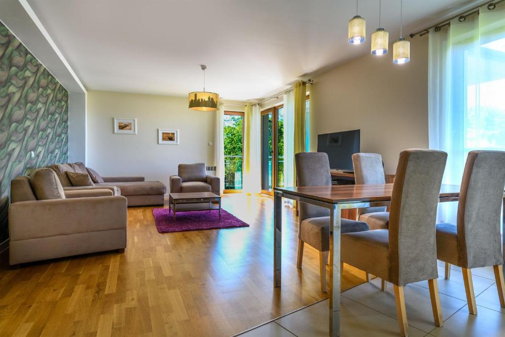 a living room with a dining room table and chairs at Apartament Helios in Jastrzębia Góra