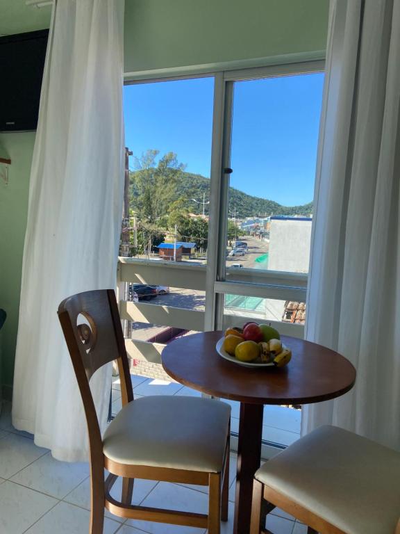 a table with a bowl of fruit on a balcony at Hotel Enseada in São Francisco do Sul