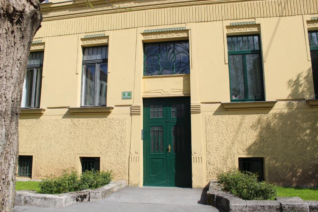 un bâtiment avec une porte et des fenêtres vertes dans l'établissement Aida, à Ljubljana