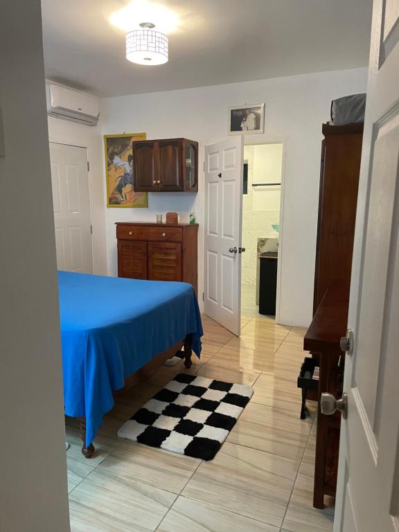 1 dormitorio con 1 cama azul y suelo a cuadros en Centrally Located Room - 5 en Port Antonio