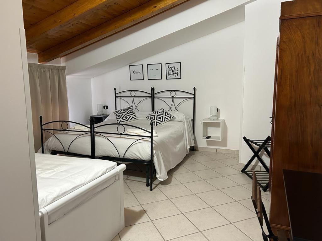 a bedroom with a black bed with pillows on it at B&B Casa Letizia in Trentinara