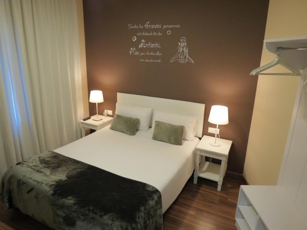 バルセロナにあるホステル プチ プリンセップのベッドルーム1室(大型ベッド1台、ナイトスタンド2台付)