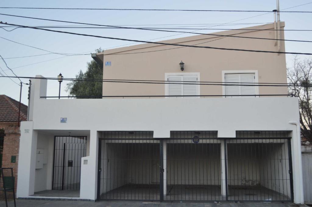 un edificio blanco con dos puertas de garaje en Monoambiente céntrico, en San Luis