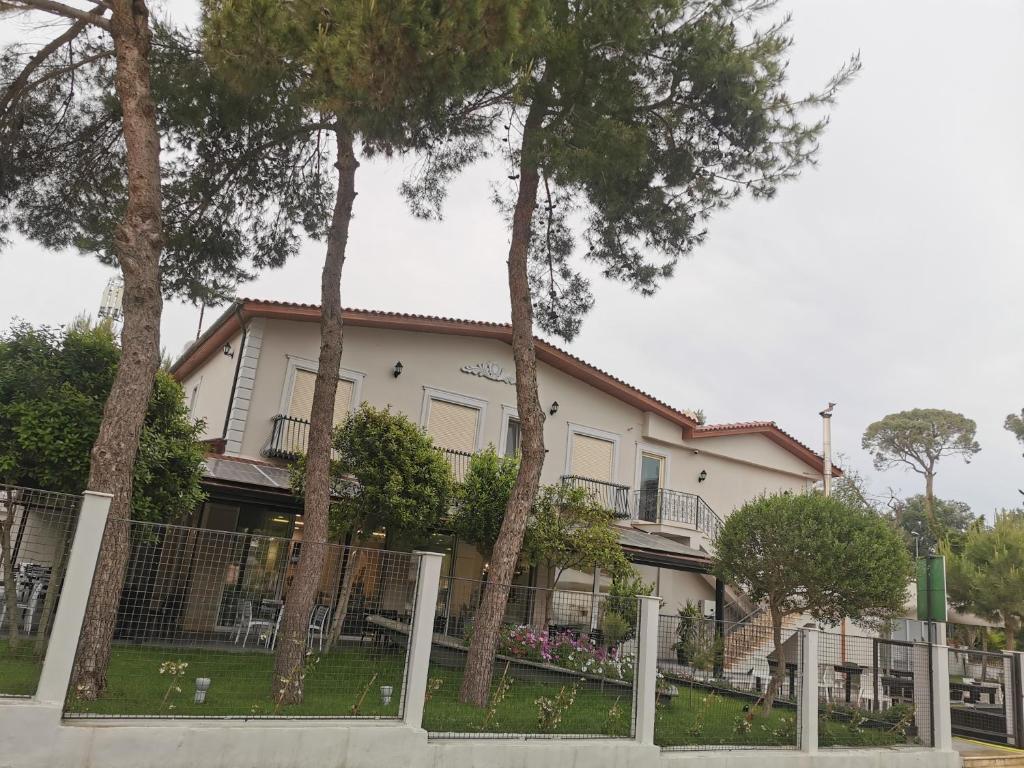 een huis met bomen voor een hek bij Hotel Pelikan in Divjakë