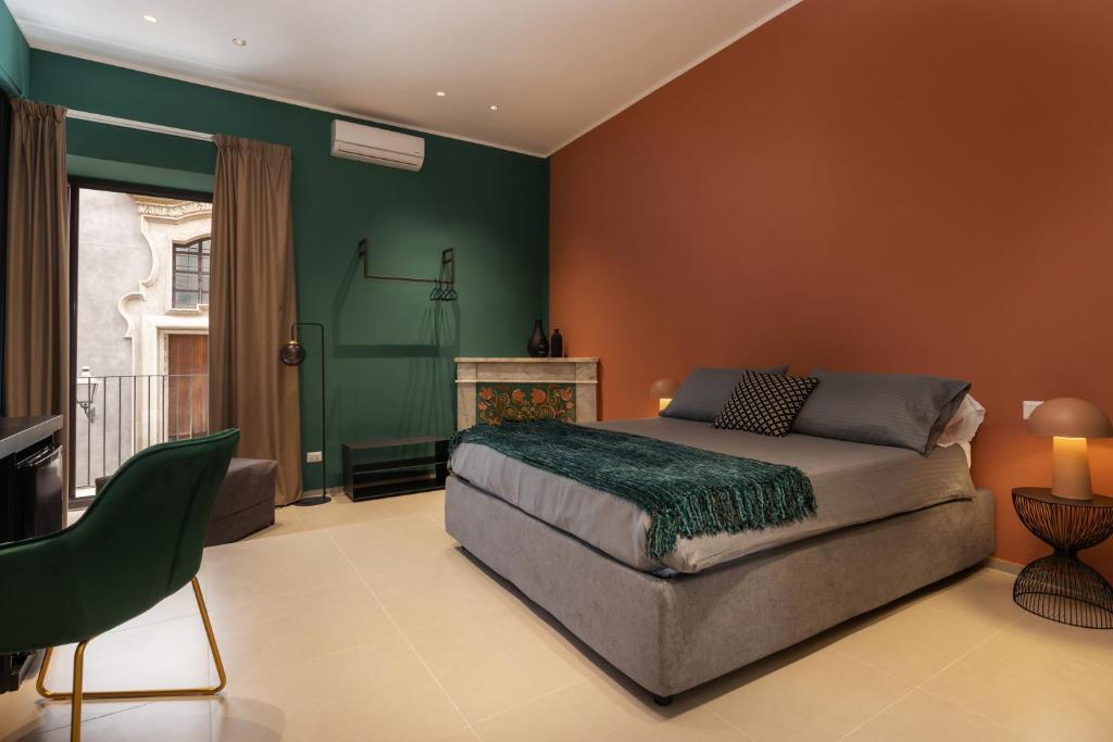 a bedroom with a bed and a green wall at La Regina del Duomo Catania Centro in Catania