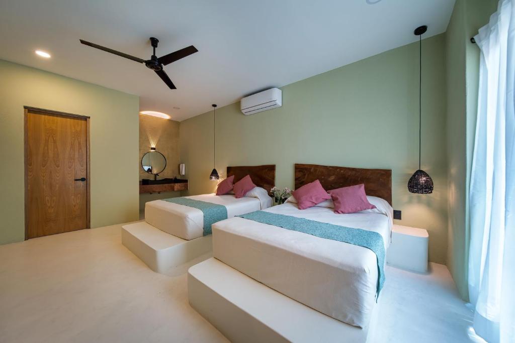 - une chambre avec 2 lits et un ventilateur de plafond dans l'établissement Hotel Bindani’, à Santa Cruz Huatulco