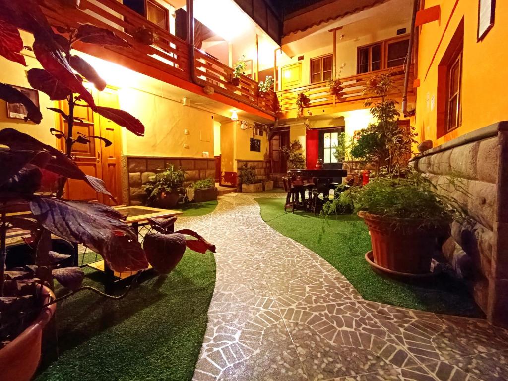 un pasillo de una casa con suelo verde y plantas en La Posada del Viajero en Cusco