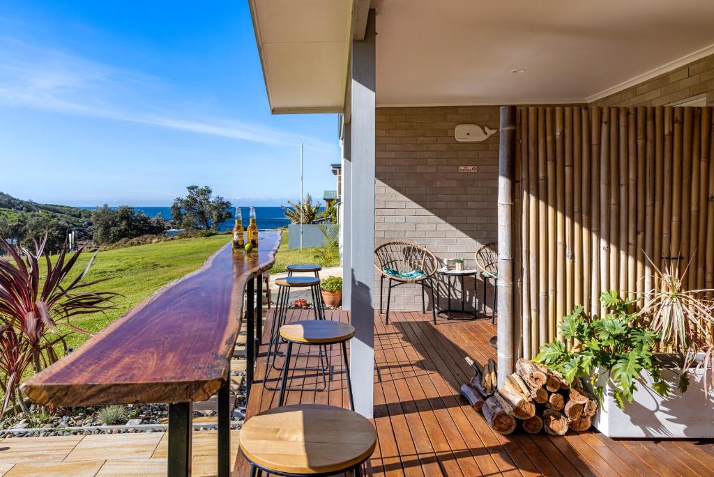 una terraza de madera con mesa y sillas en una casa en Dolphin Studio Suite, en Anna Bay