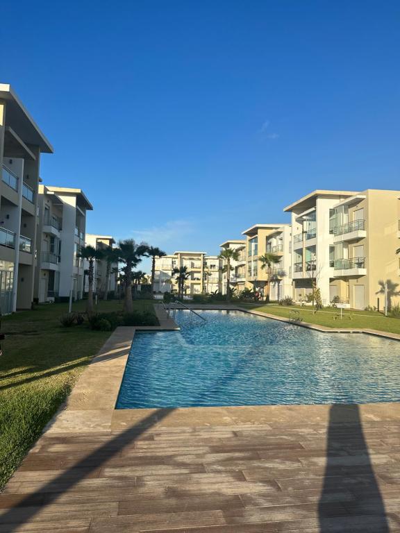 a swimming pool in front of some apartment buildings at Casa bay sidi rahal in Sidi Rahal