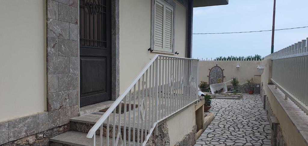 een veranda van een huis met een deur en een trap bij Agape casa vacanze in Giardini Naxos