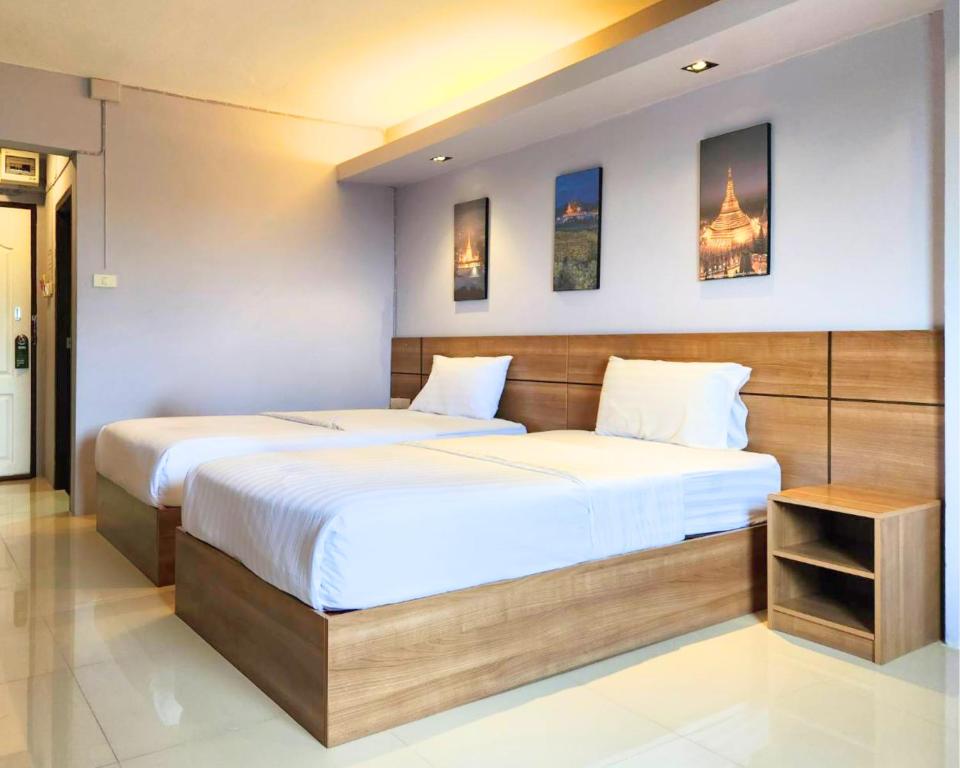 a bedroom with a large bed with white sheets at AIRBEST Gemtree Lampang Hotel in Lampang