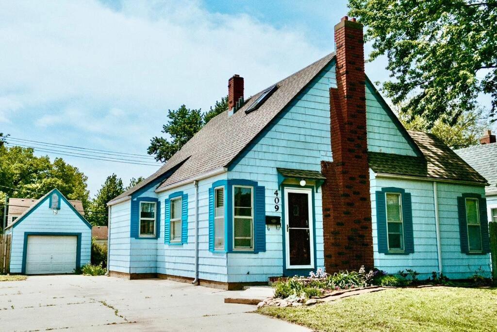 une maison bleue avec une cheminée en haut dans l'établissement Bluebird Cottage, walking distance to fairgrounds, à Hutchinson