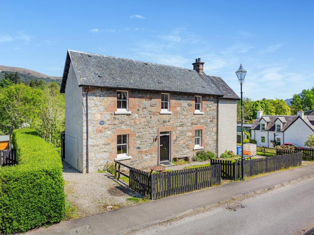 an old stone house on the side of a street at Lockview Upper Flat in Fort Augustus