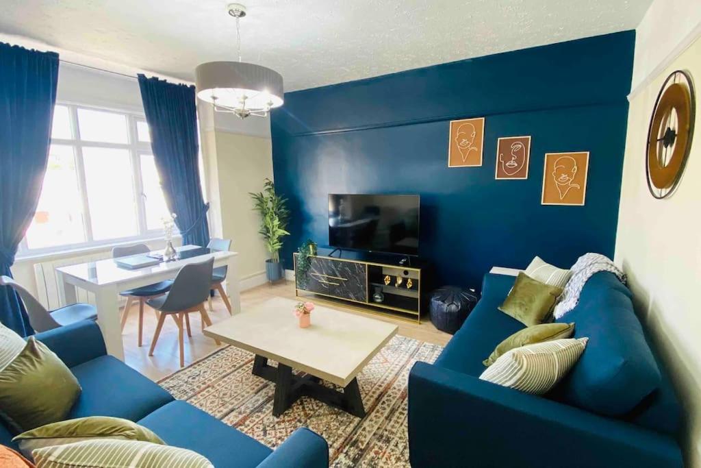 a blue living room with a blue couch and a table at Family Marine Apartment with Sea View in Dawlish