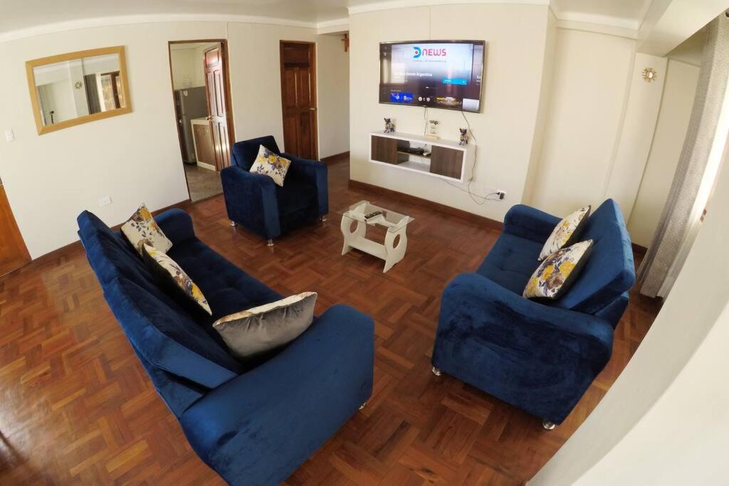 un salon avec deux chaises bleues et une télévision dans l'établissement Centric & cozy apartment with Garage, à Cusco