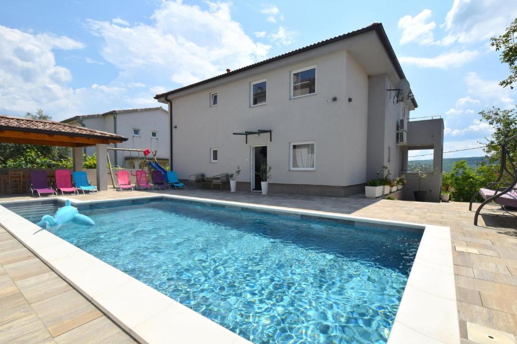 een villa met een zwembad voor een huis bij Apartment Bianca in Čižići