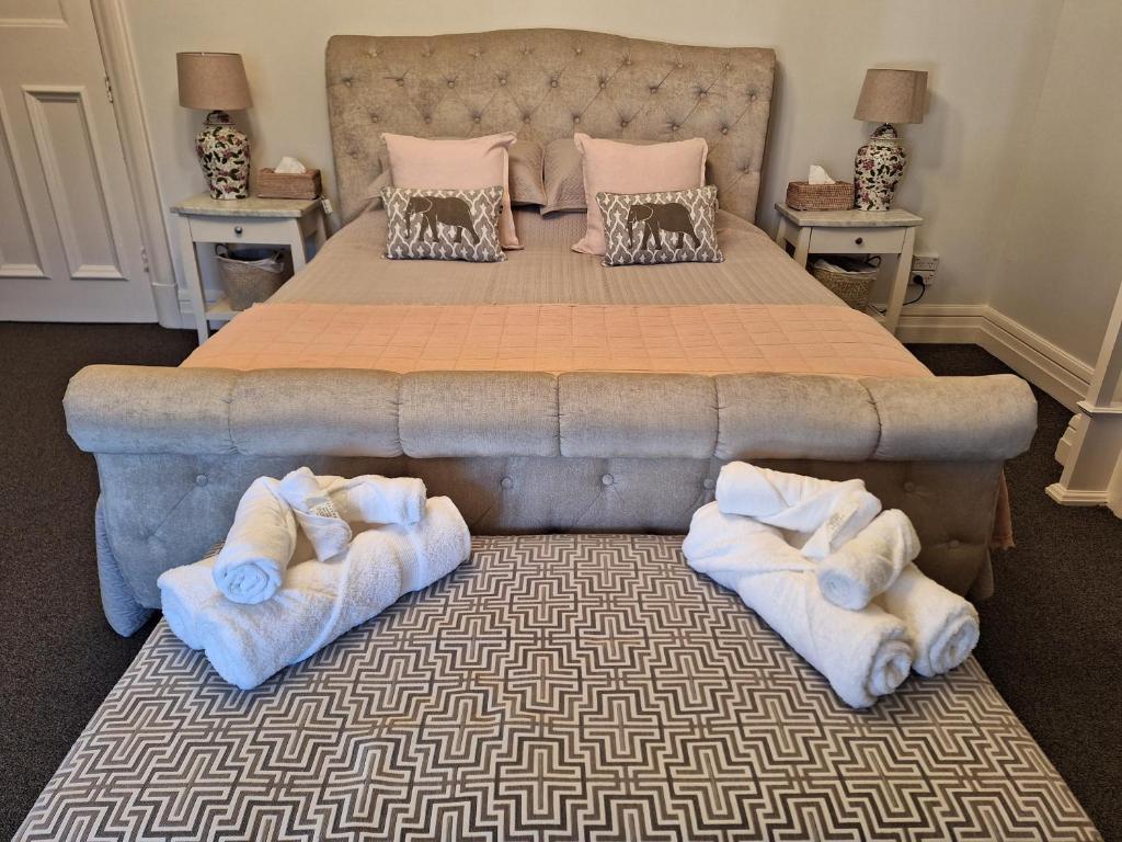 una camera da letto con un grande letto con asciugamani sul pavimento di The Bank On Kelly Hygge Villa, Scone a Scone