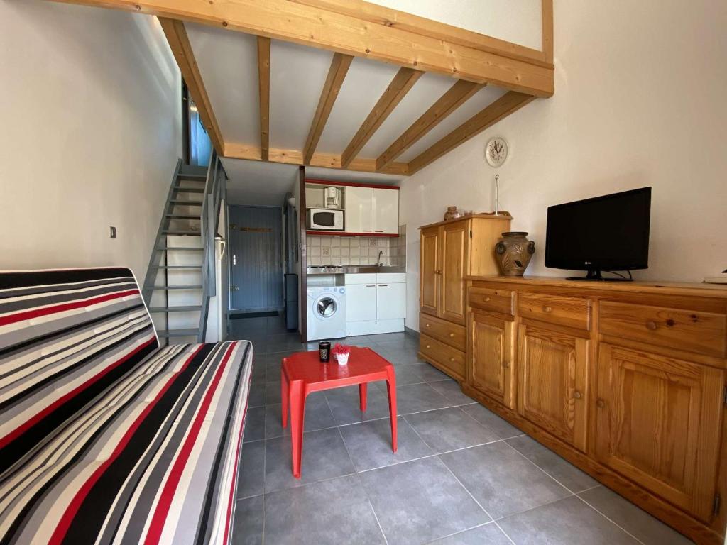 Cette chambre comprend un lit, une télévision et une cuisine. dans l'établissement Appt cosy 4 pers avec piscine et parking, proche plage à Gruissan - FR-1-229-863, à Gruissan