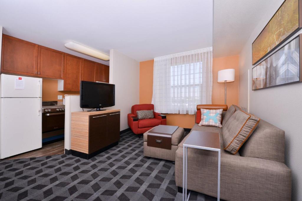 a small living room with a couch and a kitchen at TownePlace Suites by Marriott Ontario Airport in Rancho Cucamonga