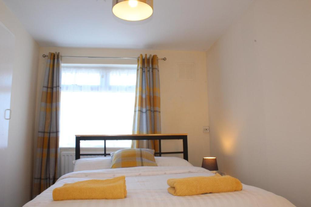 a bedroom with a bed with two yellow towels on it at Sunny South Shields House in Jarrow
