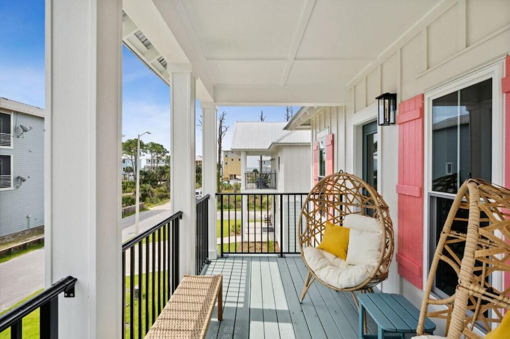 a porch with two chairs and a swing at Tortuga Tillys in Cape San Blas