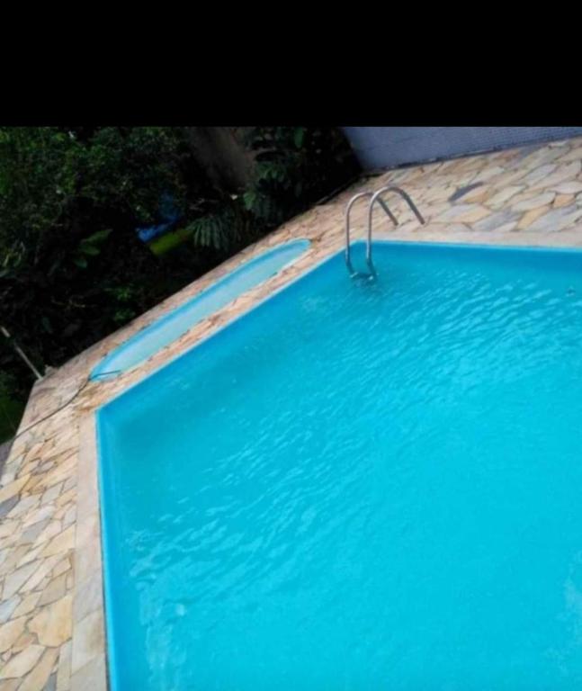 a large blue swimming pool with a metal object in it at Casa com 2 Piscinas infantil e adulto a 450m da Praia Até 15 Pessoas in São Sebastião
