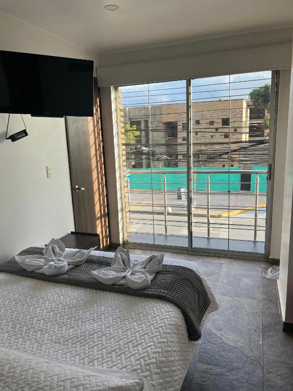 a bedroom with a bed with a view of a pool at Hotel San Martin Mosquera in Mosquera