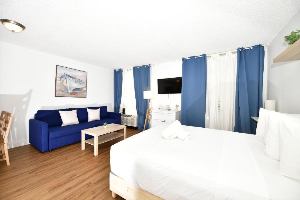a bedroom with a bed and a blue couch at Sobe Apartments in Miami Beach
