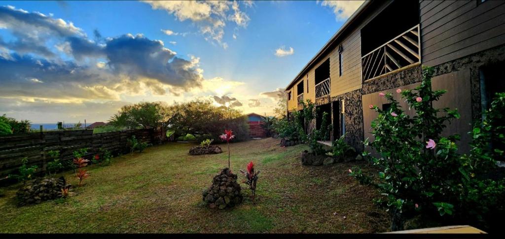 a view of a yard with a building and a person at Cabañas Tupuna Lodge in Hanga Roa