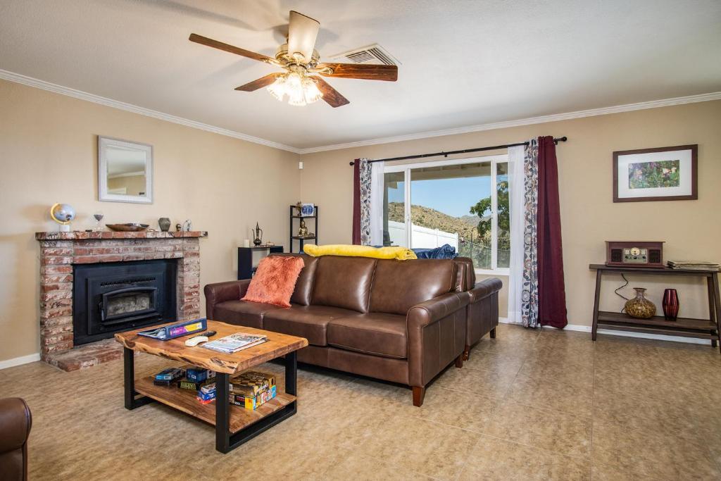 een woonkamer met een bank en een open haard bij Peaceful Home with Nature Views & Trail Access in Yucca Valley