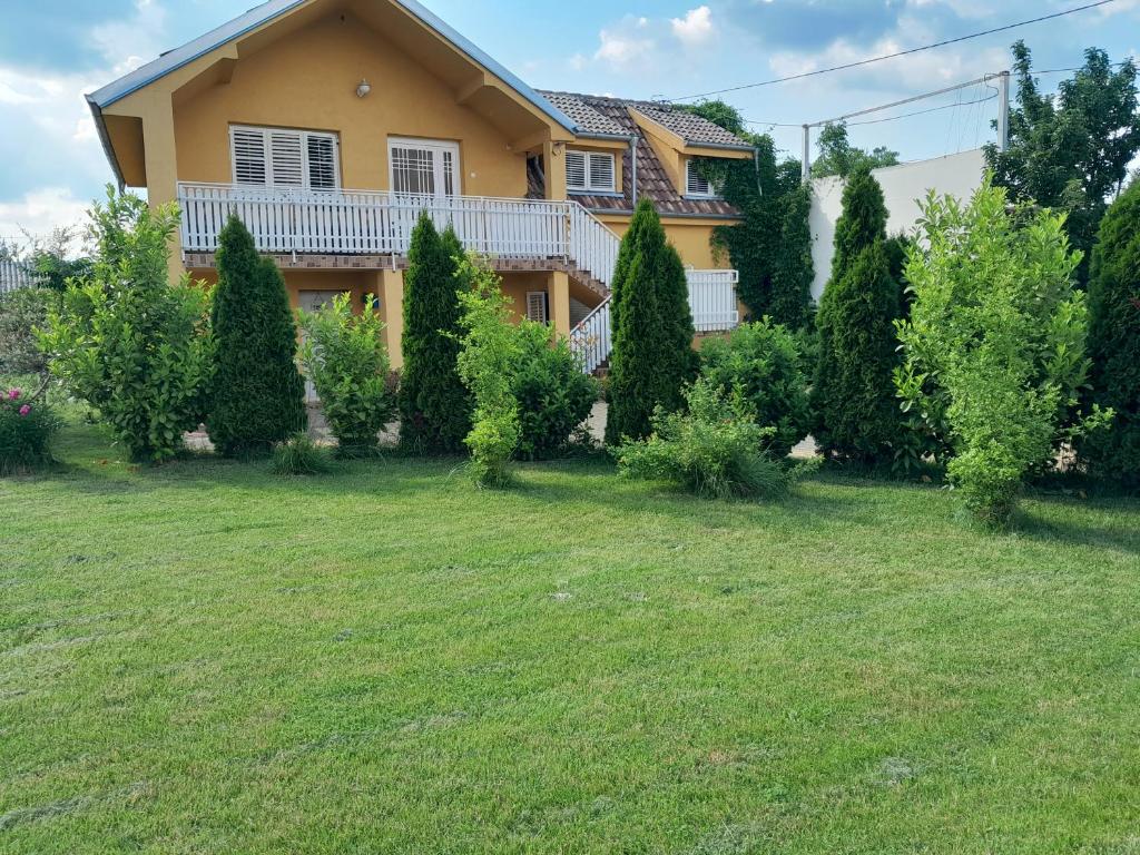 ein Haus mit einem Garten mit Bäumen und Sträuchern in der Unterkunft Golden House Apartments in Čačak