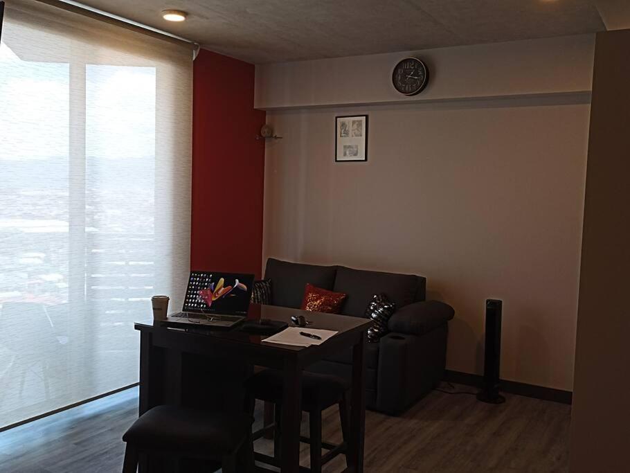 a living room with a couch and a table with a laptop at Secrt 1914 in San José