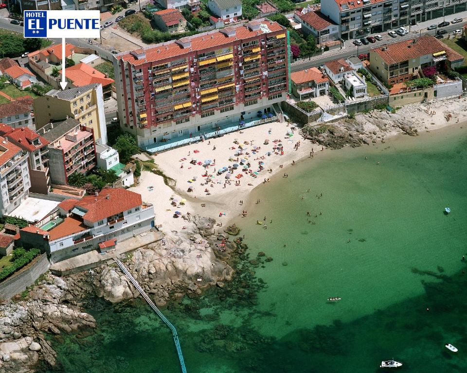 an aerial view of a beach with people in the water at Hotel El Puente in Sanxenxo