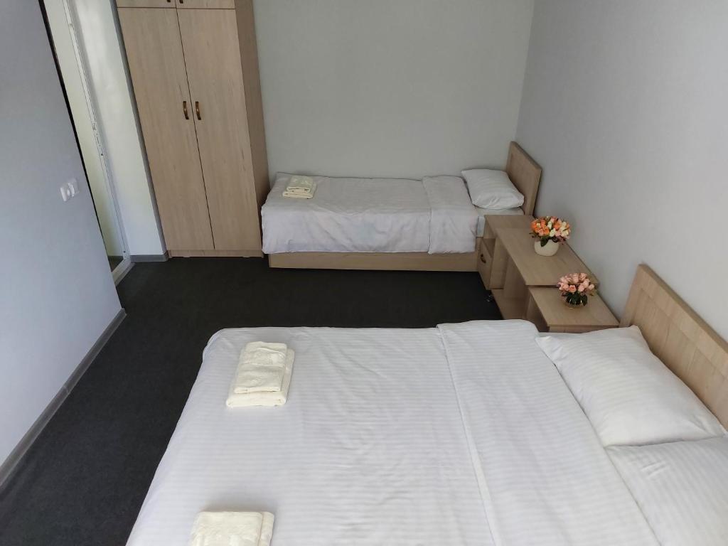 um pequeno quarto com duas camas num quarto em Aisha Registan em Samarkand