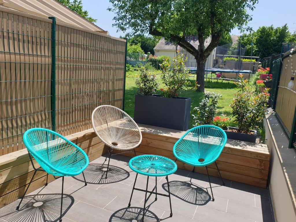 trzy krzesła i stół na patio w obiekcie Cocon à la campagne - Disney 20 min - Paris 40 min - 2 terrasses w mieście Dammartin-sur-Tigeaux