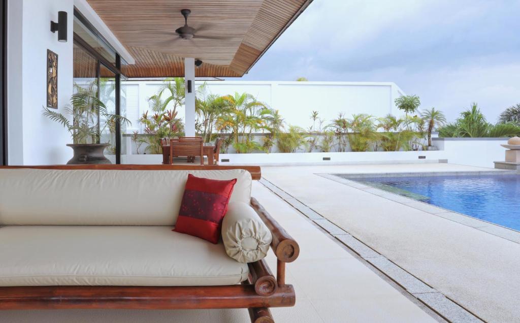 a living room with a couch and a swimming pool at Kulraya Villas - Luxury Serviced Pool Villas (A) in Ko Lanta