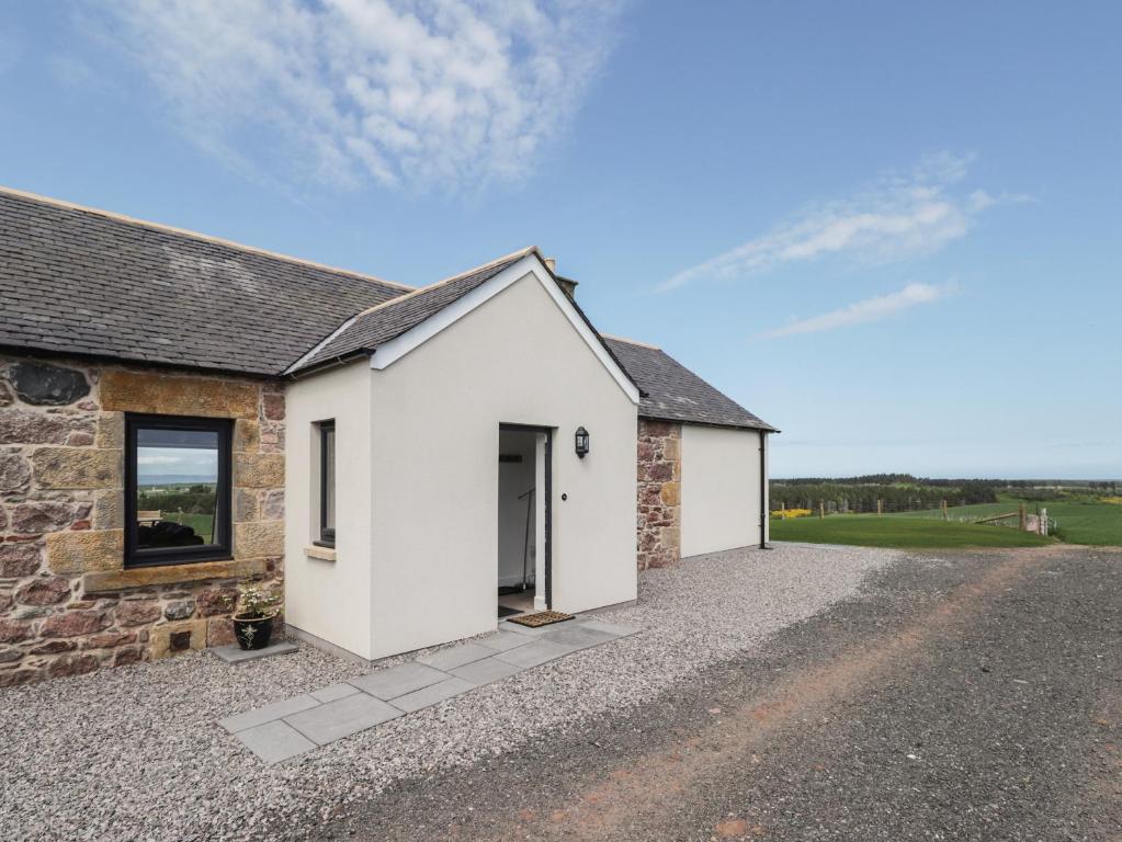 a detached stone house with a driveway at Firthview in Nairn