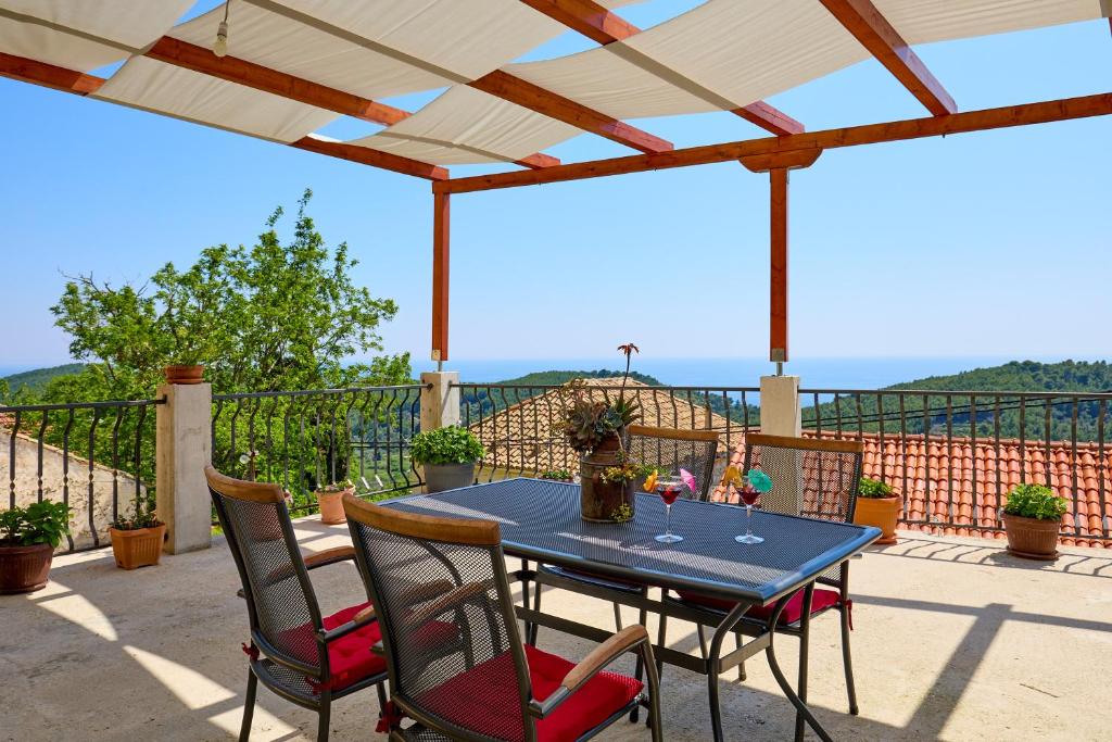 una mesa azul y sillas en un patio con vistas en Stone House Biskup, en Babino Polje