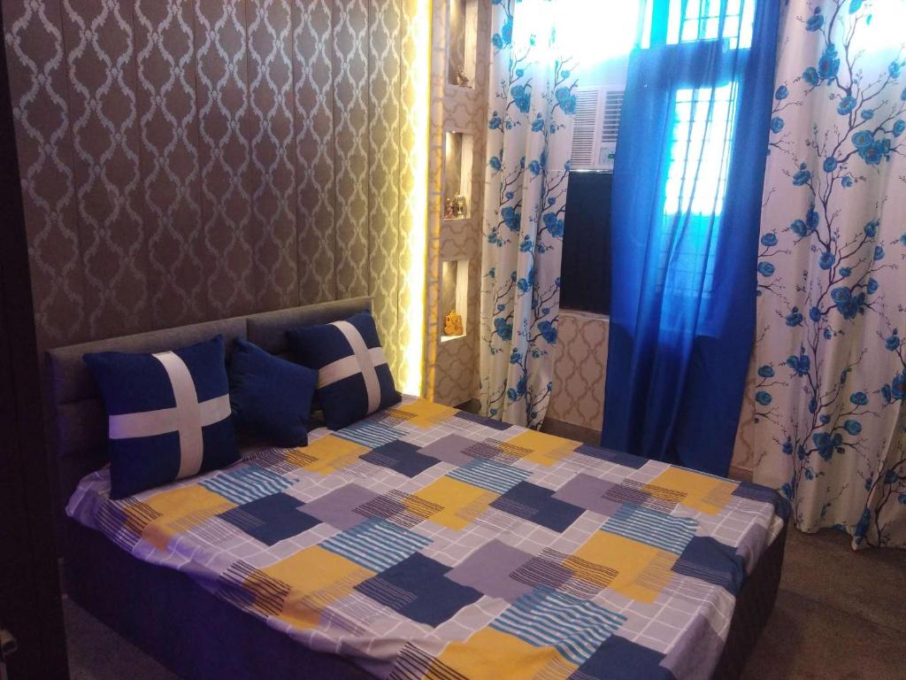 a bedroom with a bed with a colorful quilt at ASHIANA HOME STAY in Jammu
