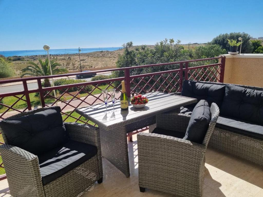 a patio with a table and chairs on a balcony at Vista al Mar with Parking Space in La Mata