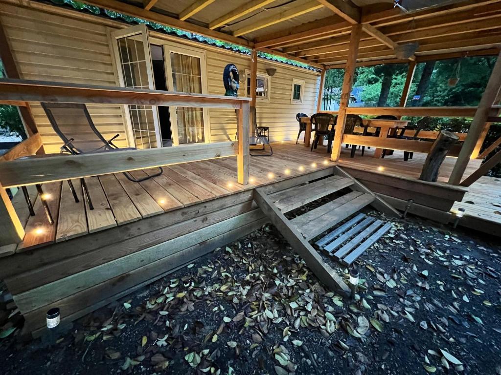 a front porch of a wooden cabin with a bench at Bungalow de 2 chambres avec piscine partagee jardin clos et wifi a Saint Jean de Valeriscle in Saint-Jean-de-Valériscle