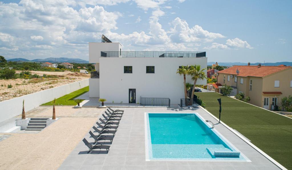 a villa with a swimming pool and a house at Rooftop House Vodice in Vodice