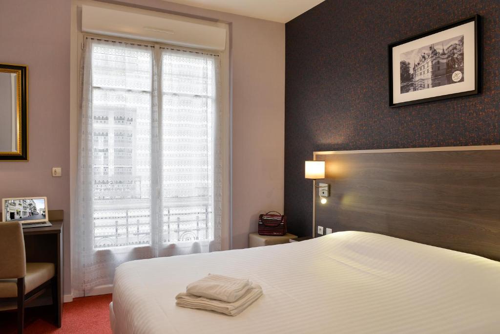 a hotel room with a bed and a window at Logis Hôtel Des Châteaux De La Loire in Tours