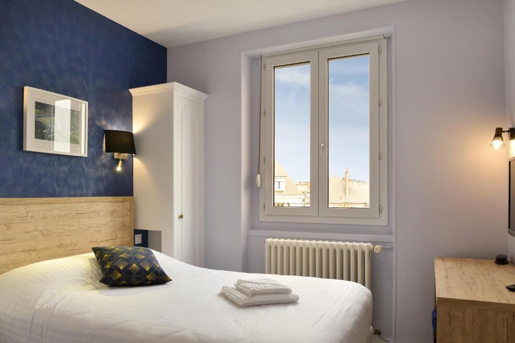 1 dormitorio con cama blanca y ventana en Logis Hôtel Des Châteaux De La Loire en Tours